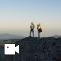 Un couple se tient au sommet d'une montagne