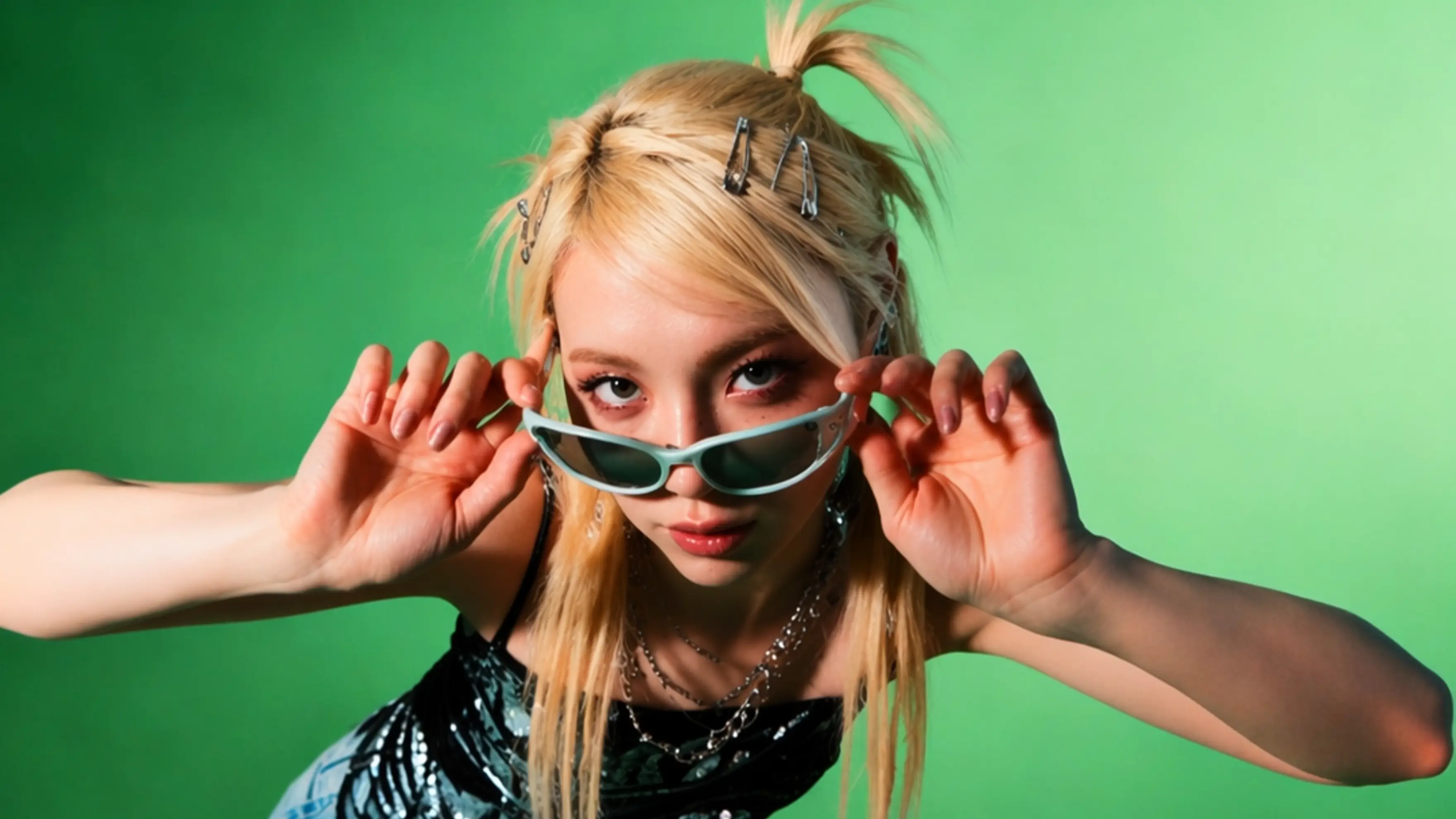 Stylish Gen-Z virtual model with Y2K hair clips looking over sunglasses on a green background