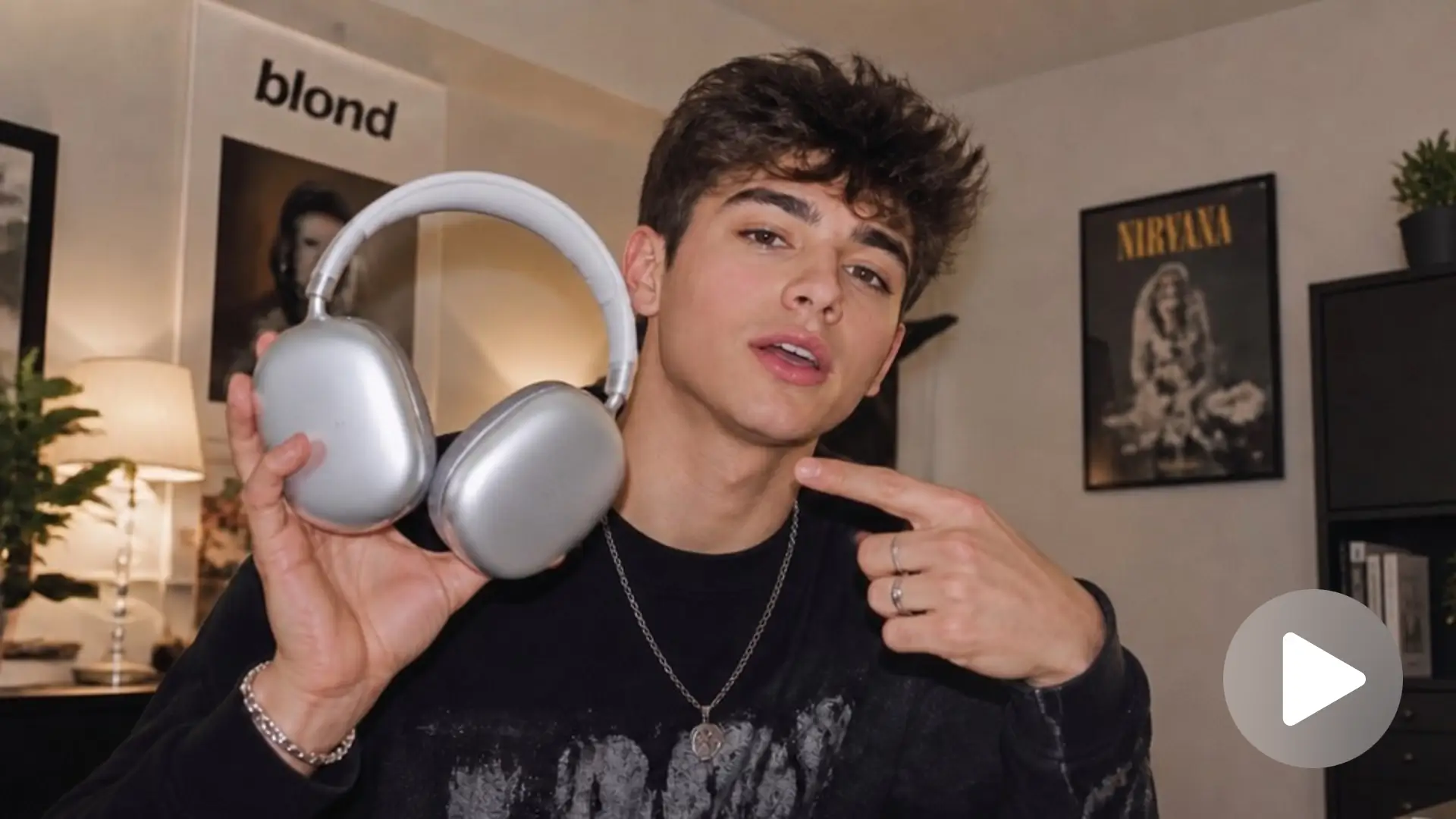 AI UGC-style avatar video thumbnail of a young male influencer holding silver headphones, demonstrating product reviews
